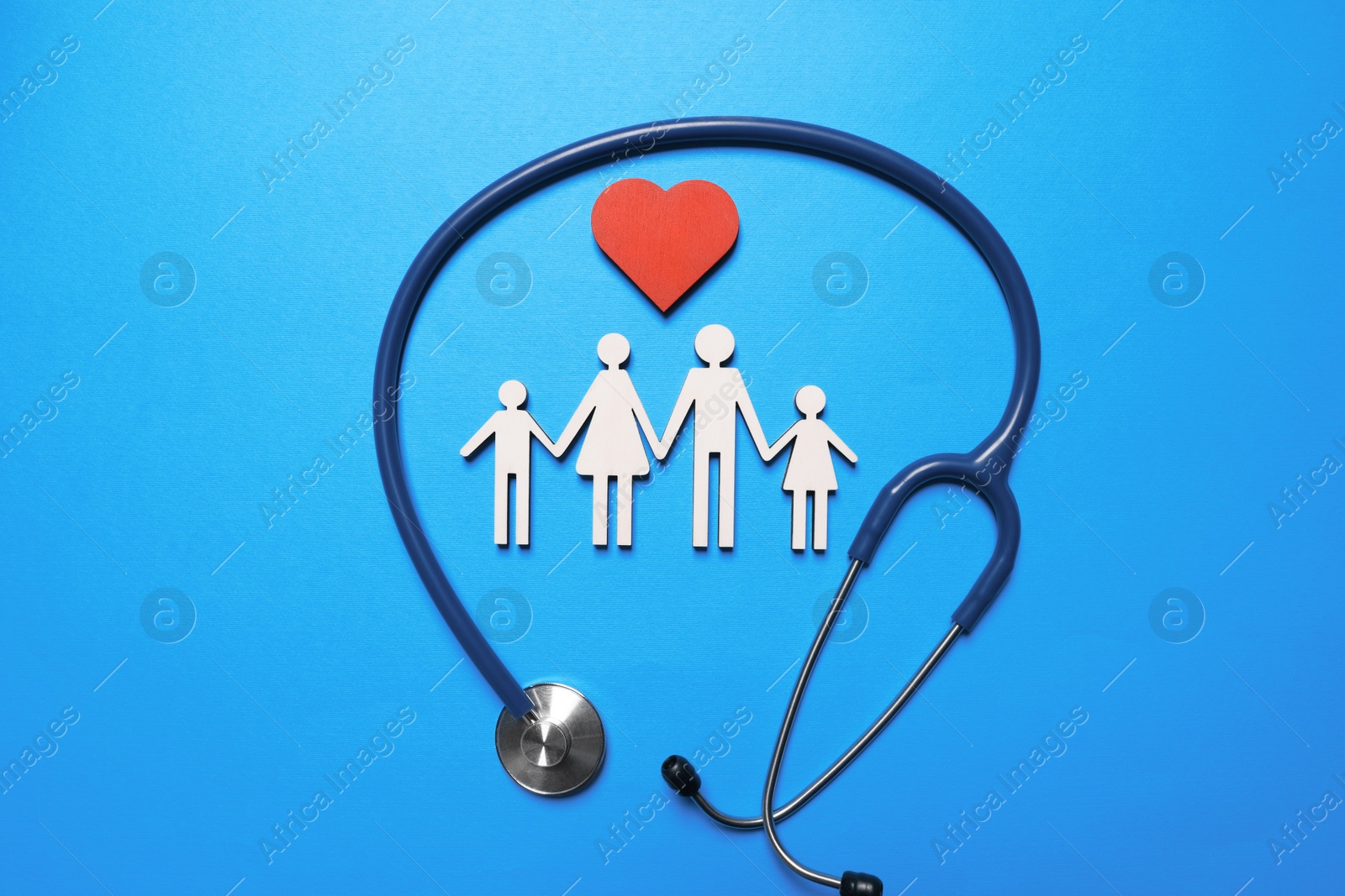 Photo of Figures of family near stethoscope on light blue background, flat lay. Insurance concept
