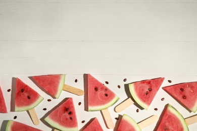 Photo of Slices of ripe watermelon on white wooden table, flat lay. Space for text