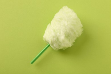 Photo of Sweet cotton candy on green background, top view