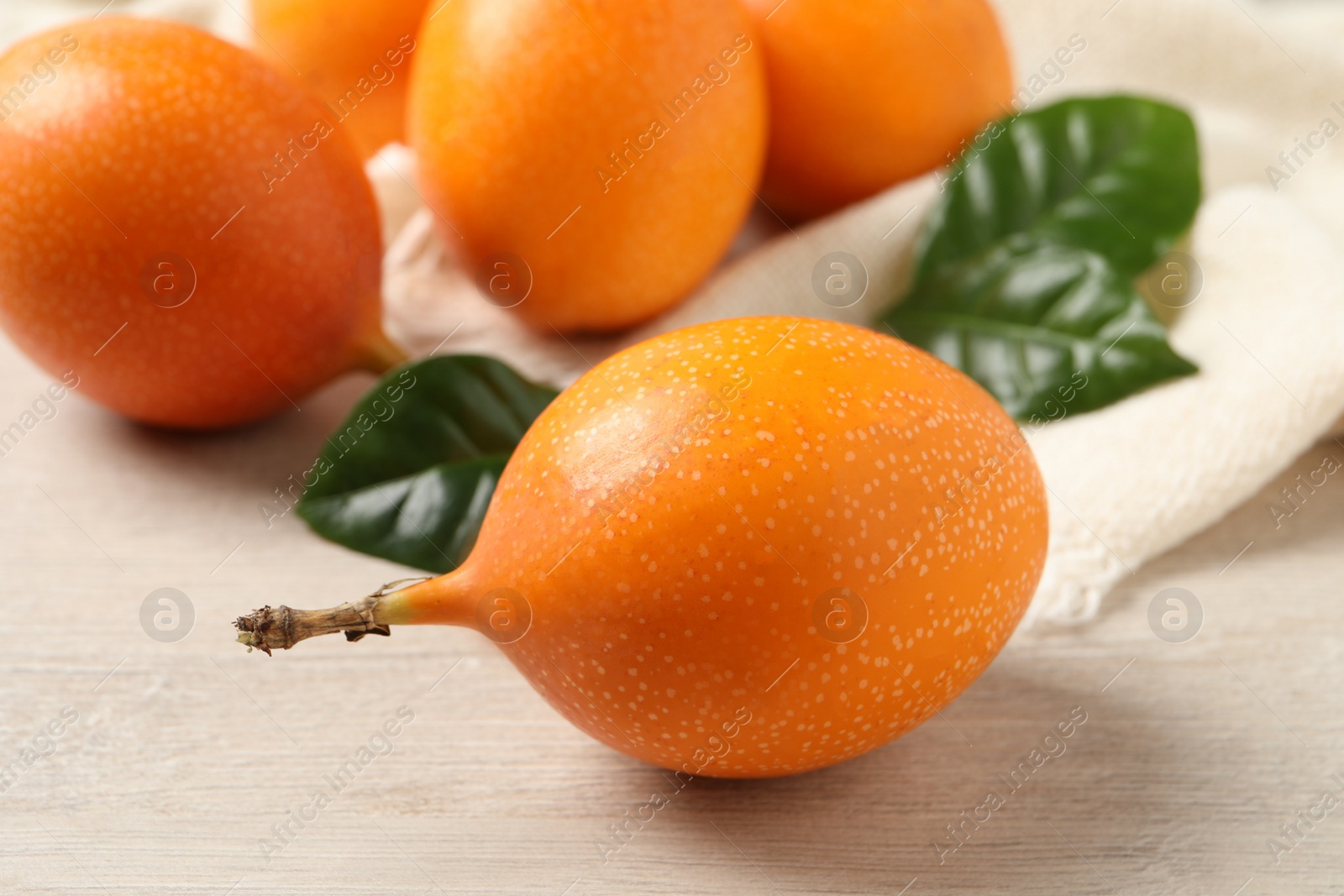 Photo of Delicious ripe granadillas on white wooden table, closeup