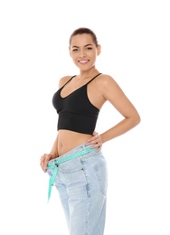 Photo of Slim woman in oversized jeans with measuring tape on white background. Weight loss