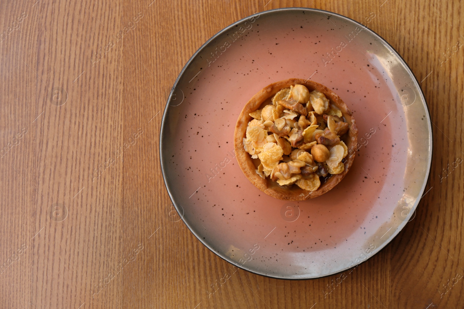 Photo of Plate with delicious cake on wooden table, top view