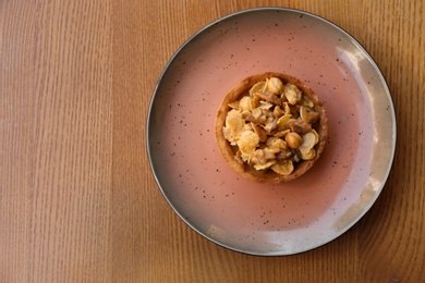 Photo of Plate with delicious cake on wooden table, top view