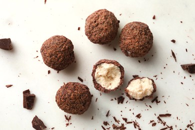 Many delicious chocolate truffles on white table, flat lay