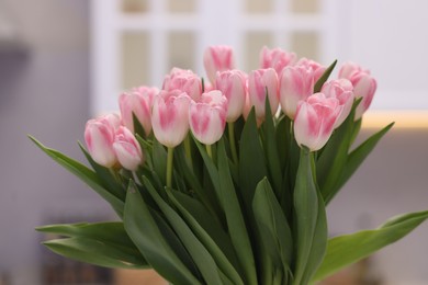 Beautiful bouquet of fresh pink tulips in kitchen, closeup