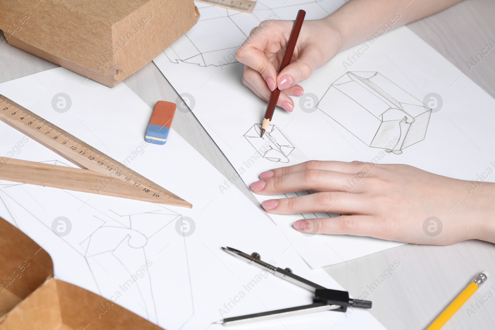 Photo of Woman creating packaging design at light wooden table, closeup