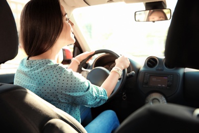 Photo of Young woman on driver's seat of car