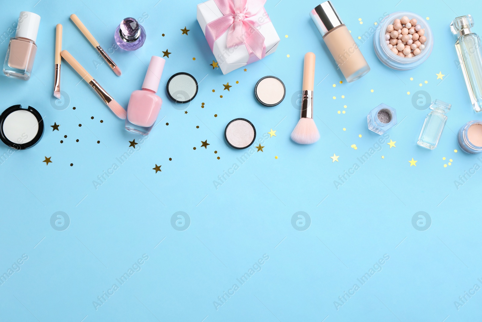 Photo of Flat lay composition with decorative cosmetic products on light blue background, space for text. Winter care