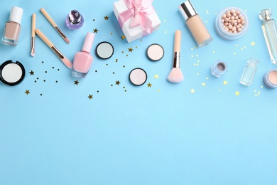 Photo of Flat lay composition with decorative cosmetic products on light blue background, space for text. Winter care