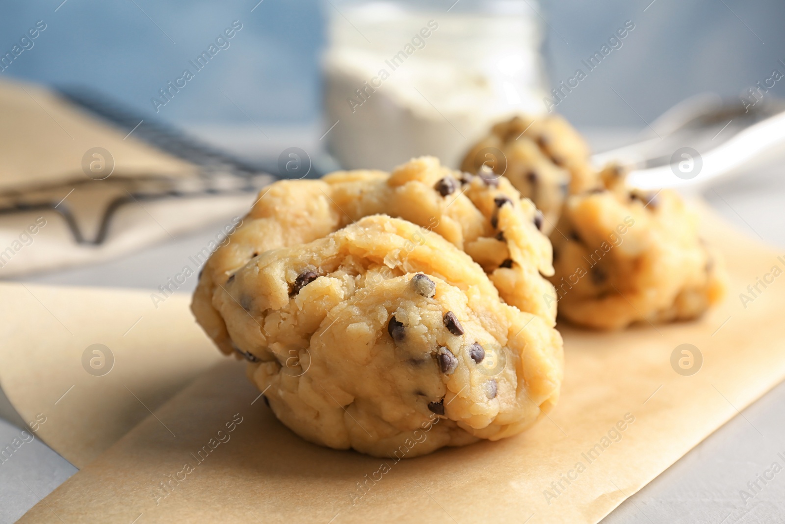 Photo of Raw cookie dough with chocolate chips on table, closeup