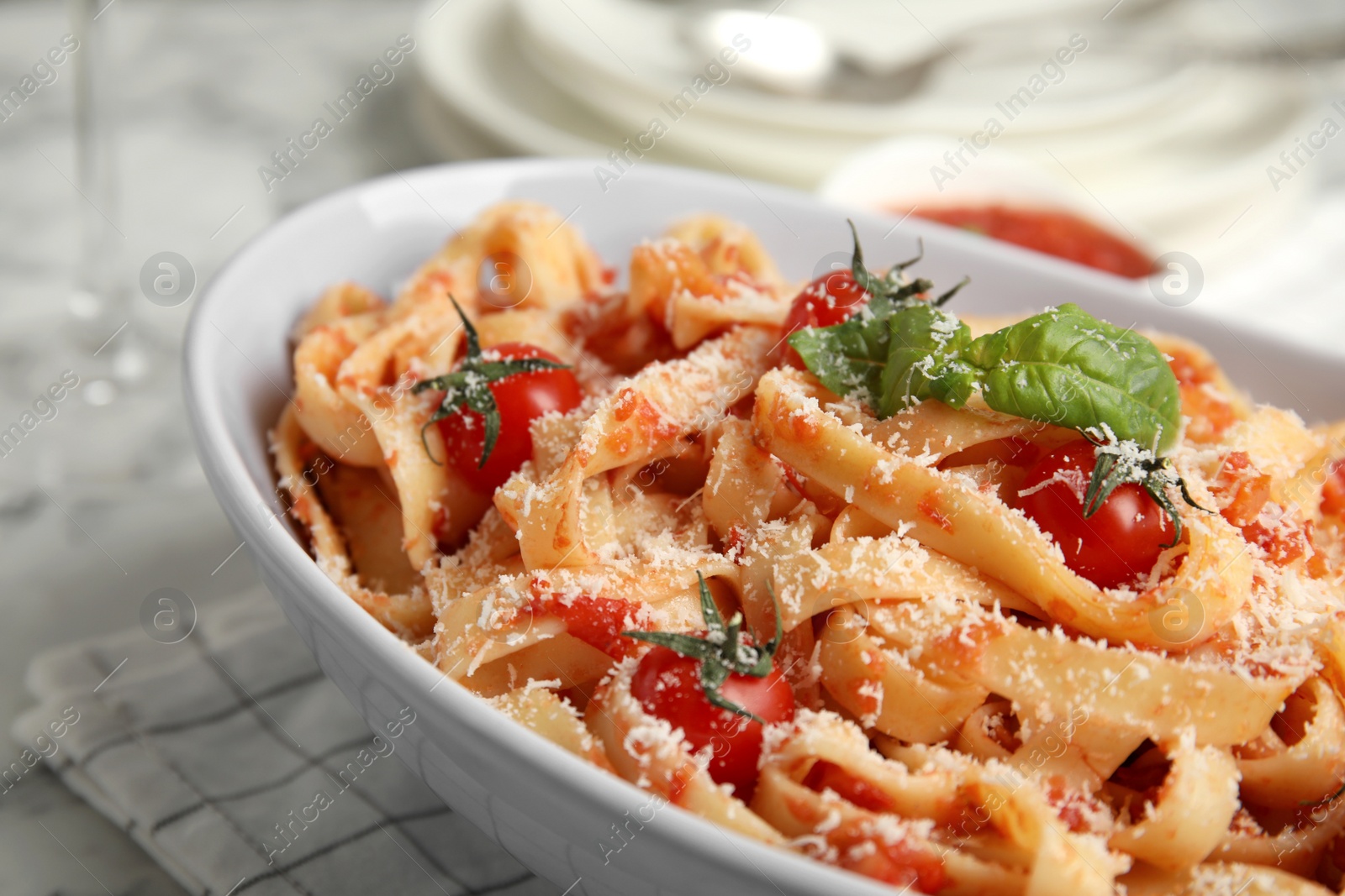 Photo of Tasty pasta with tomatoes, cheese and basil on table, closeup