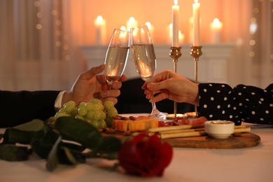 Photo of Couple clinking glasses of champagne in restaurant, closeup. Romantic dinner