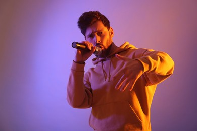 Singer with microphone rapping in color lights