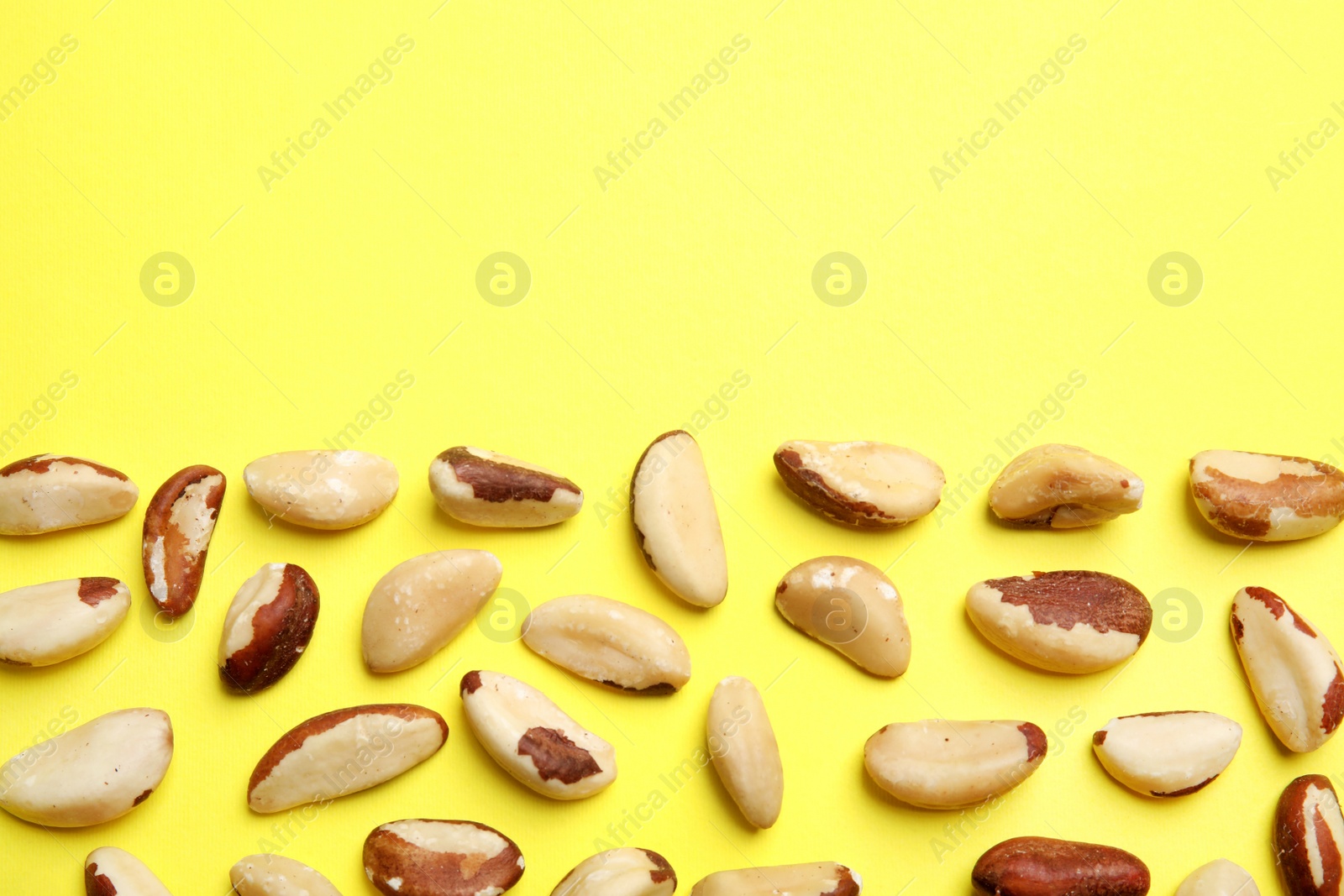 Photo of Flat lay composition with Brazil nuts and space for text on color background