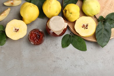 Photo of Delicious quince jam and fruits on light grey table, flat lay. Space for text