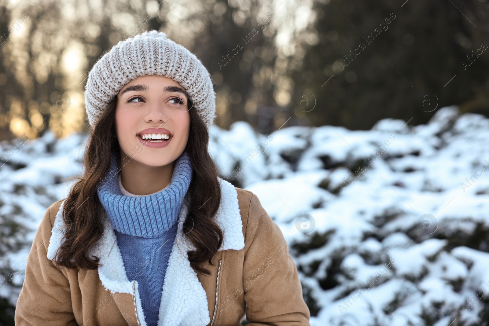 Photo of Portrait of happy woman in snowy park. Space for text