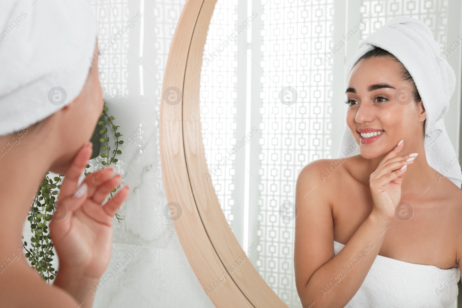 Photo of Beautiful young woman with perfect skin near mirror in bathroom. Facial wash