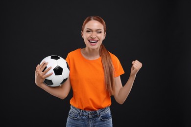 Photo of Happy fan with football ball on black background