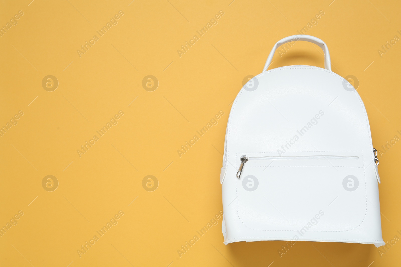 Photo of Stylish urban backpack on yellow background, top view. Space for text