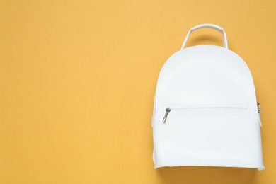 Photo of Stylish urban backpack on yellow background, top view. Space for text