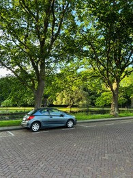 Photo of Modern car parked near lake on sunny day
