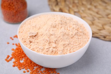 Photo of Lentil flour and seeds on white table, closeup