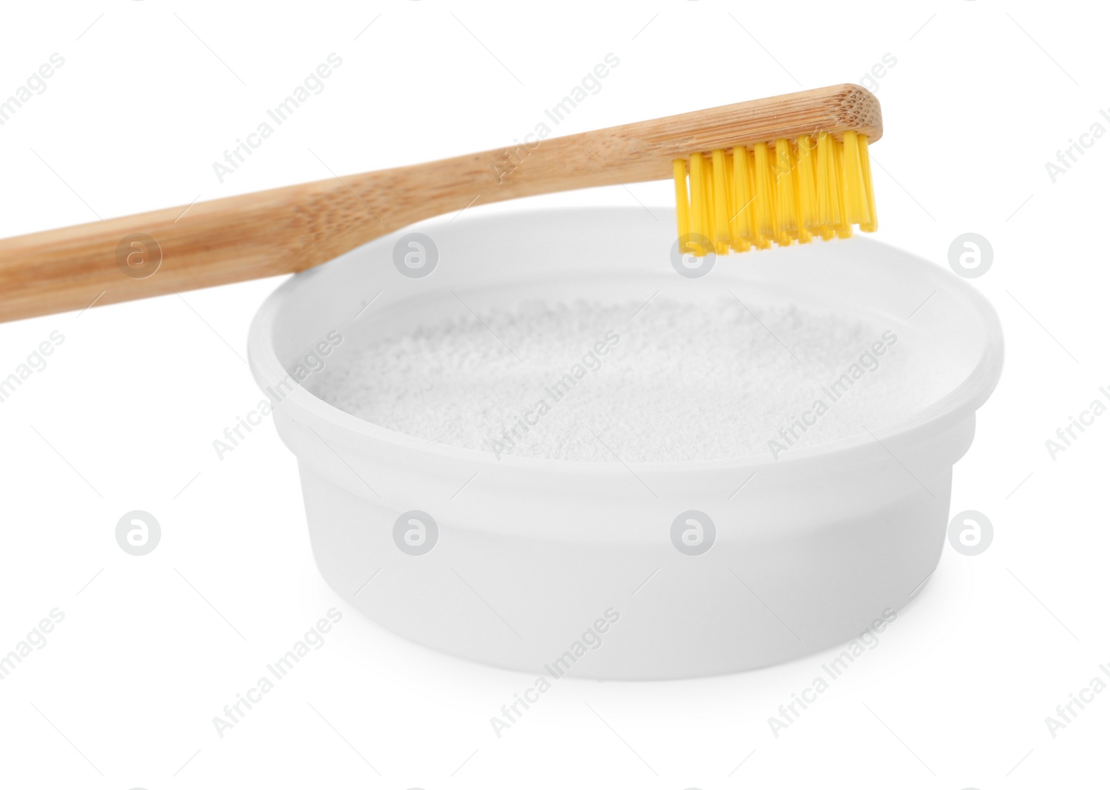 Photo of Bowl of tooth powder and brush on white background