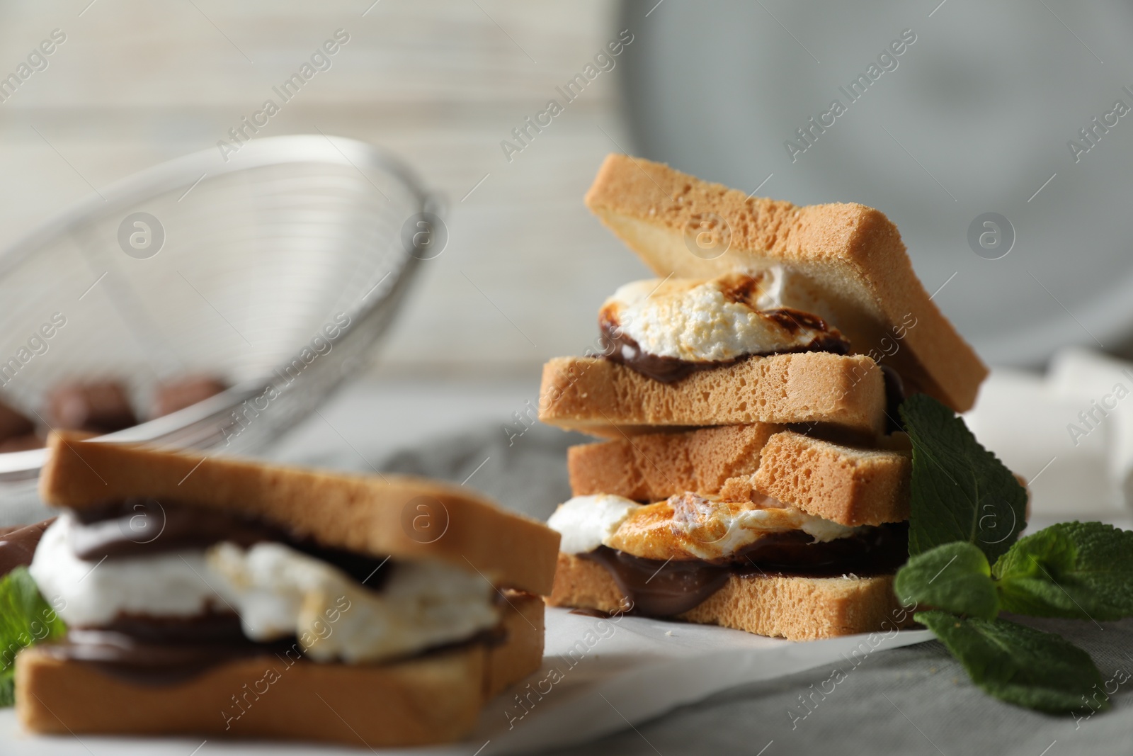 Photo of Delicious marshmallow sandwich with bread and chocolate on white wooden table, closeup