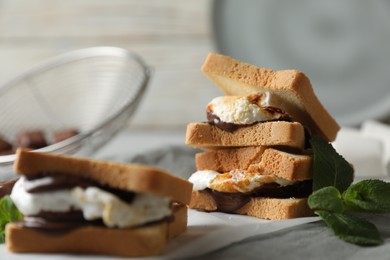 Delicious marshmallow sandwich with bread and chocolate on white wooden table, closeup