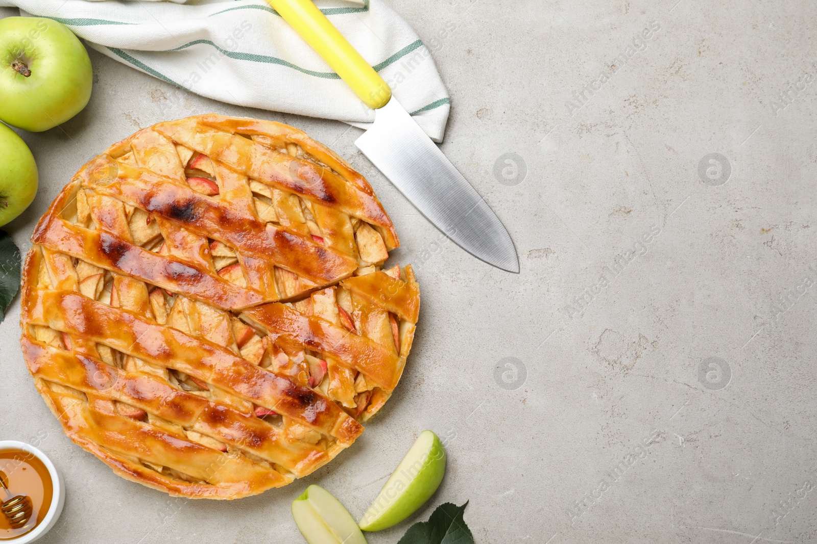 Photo of Traditional apple pie and ingredients on light grey table, flat lay. Space for text