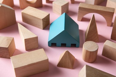 Photo of One turquoise toy building block among others on pink background. Diversity concept