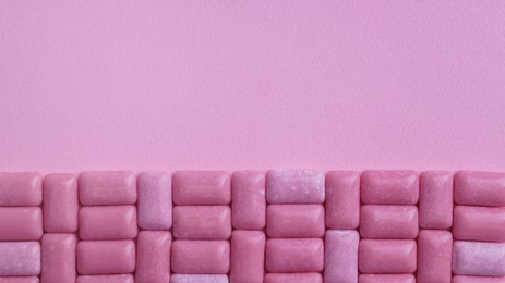 Photo of Many sweet chewing gums on pink background, flat lay. Space for text