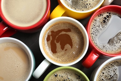 Many cups with tasty aromatic coffee on table, flat lay