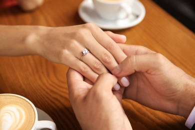Photo of Man with engagement ring making proposal to his girlfriend in cafe, closeup