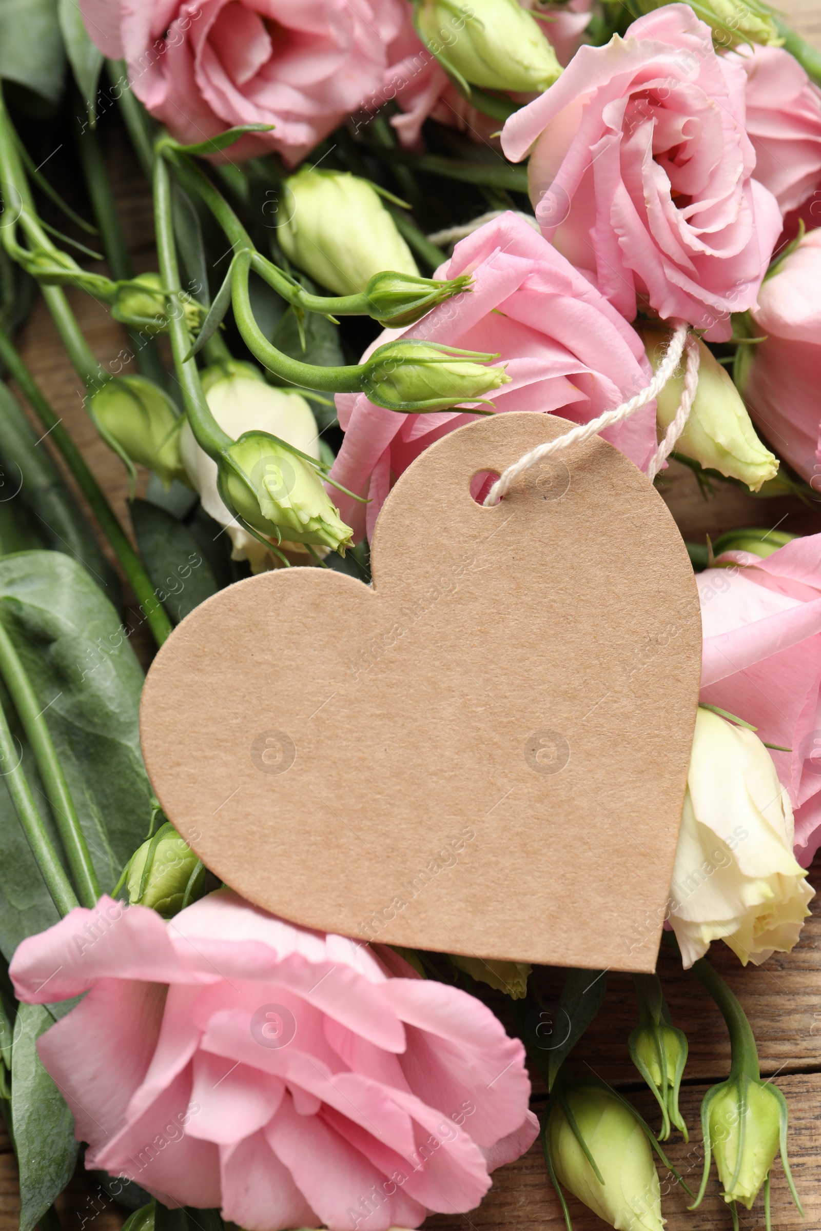 Photo of Happy Mother's Day. Beautiful flowers and blank heart shaped card on wooden table