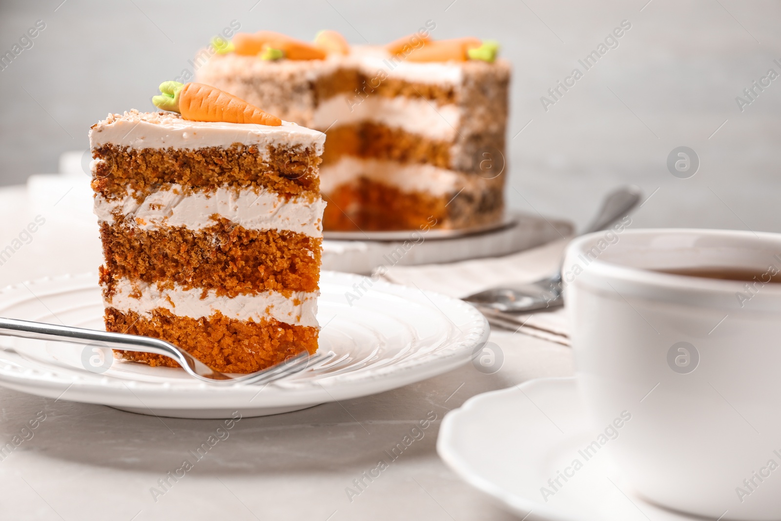 Photo of Sweet carrot cake with delicious cream on white marble table