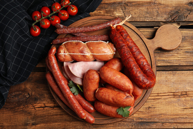 Photo of Different tasty sausages on wooden table, flat lay
