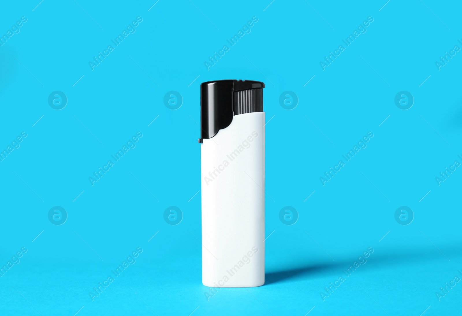 Photo of White plastic cigarette lighter on light blue background