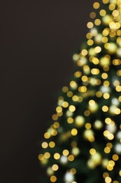 Photo of Blurred view of beautifully decorated Christmas tree on brown background