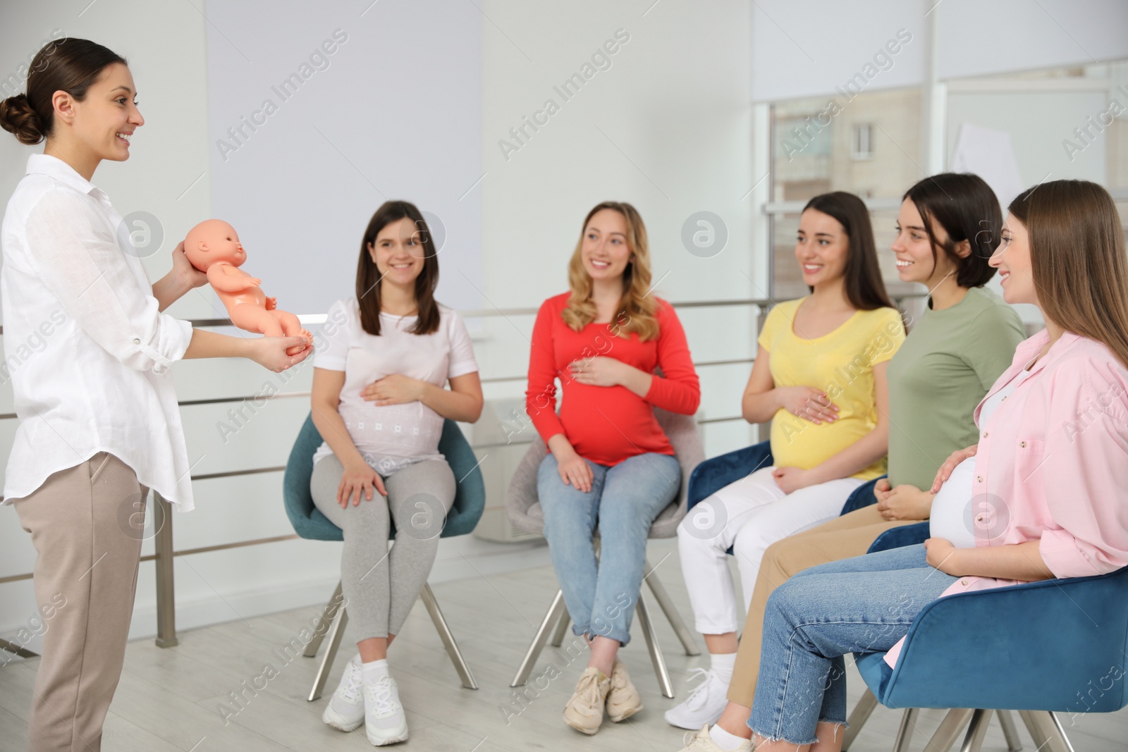 Photo of Group of pregnant women with midwife at courses for expectant mothers indoors