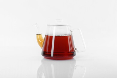 Tasty tea in teapot on white background