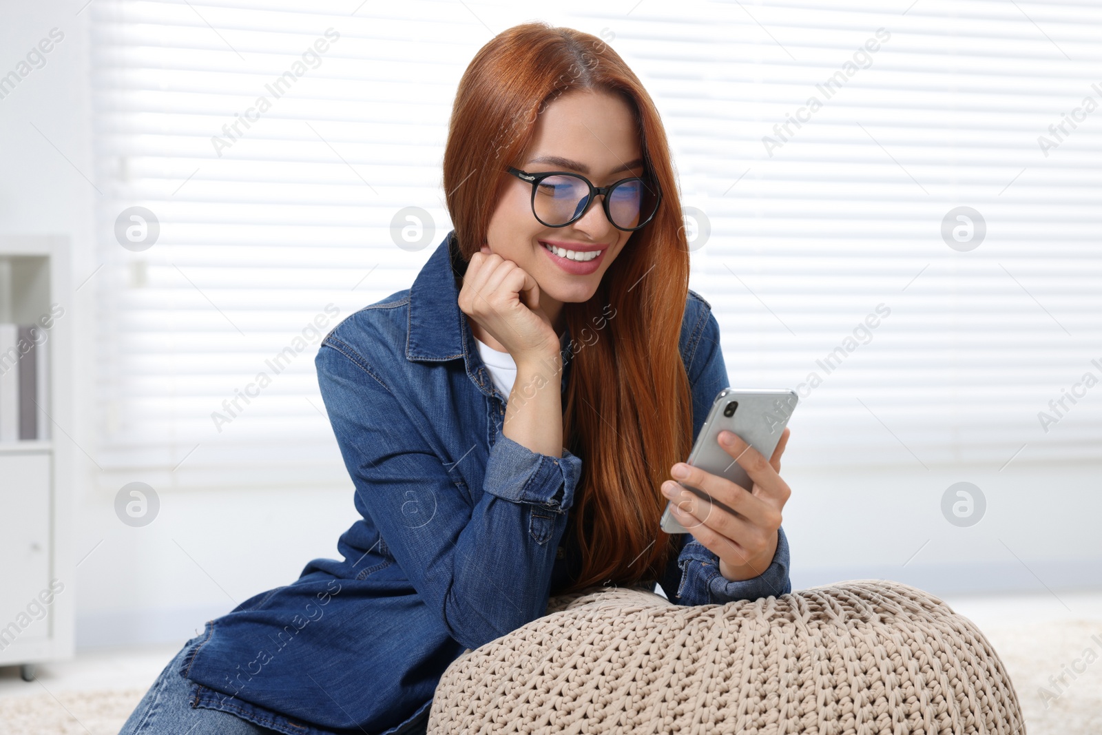 Photo of Happy young woman having video chat via smartphone at home