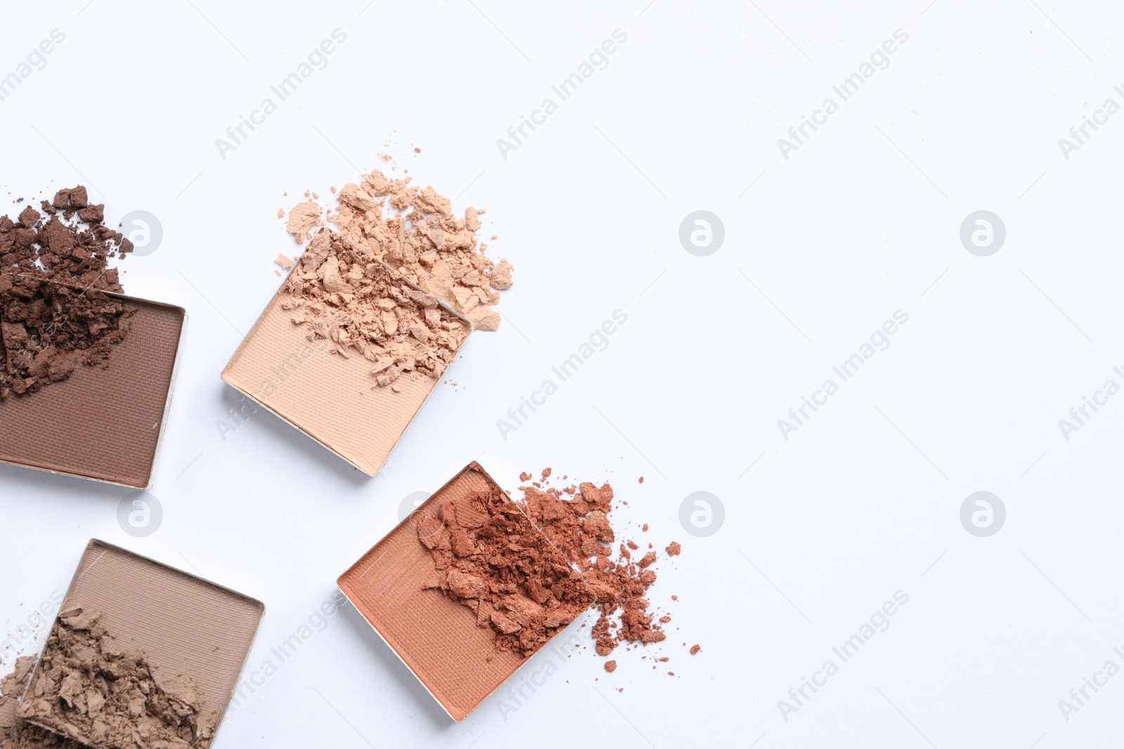 Photo of Crushed eye shadows on white background, flat lay with space for text. Professional makeup product