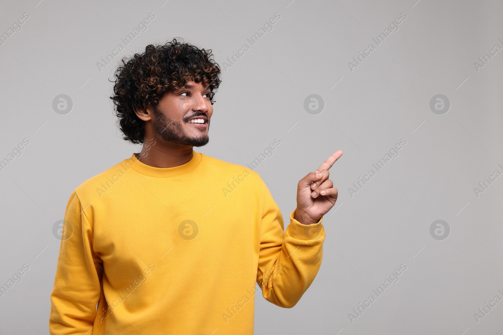 Photo of Handsome smiling man on light grey background, space for text