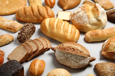 Photo of Different kinds of fresh bread on light background