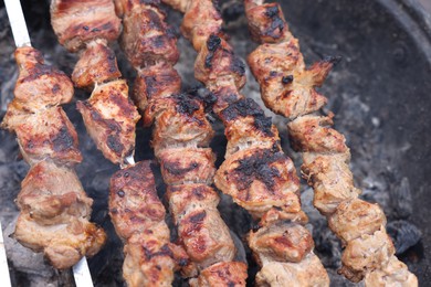 Photo of Cooking delicious kebab on metal brazier, above view