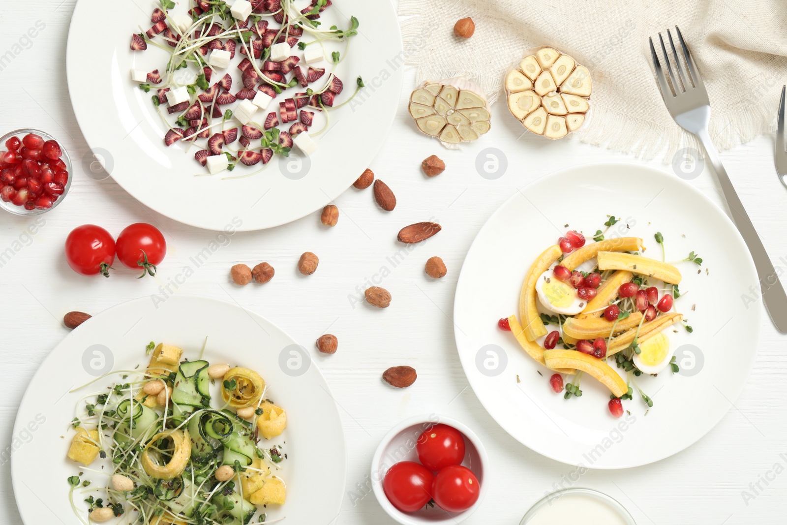 Photo of Delicious fresh carrot salads served on white wooden table, flat lay