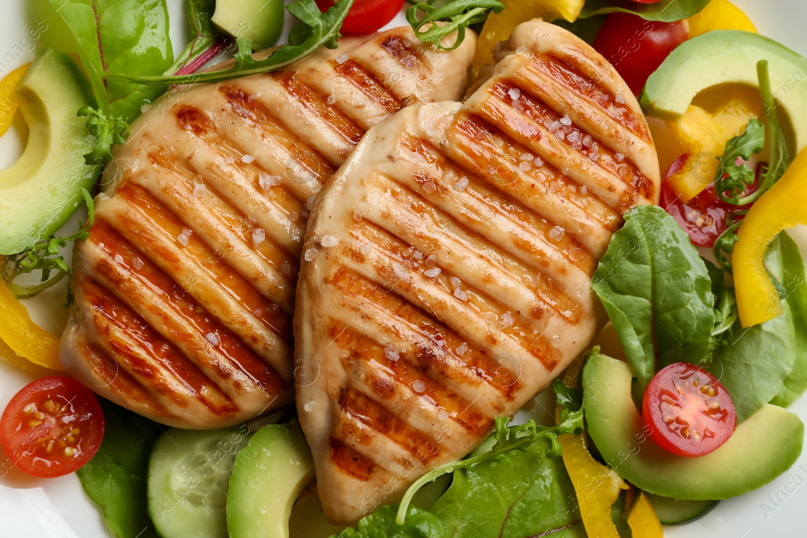 Photo of Tasty grilled chicken fillets with vegetables on plate, closeup