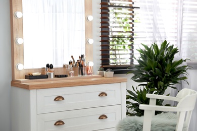 Photo of Dressing table with luxury cosmetics and accessories in room near window