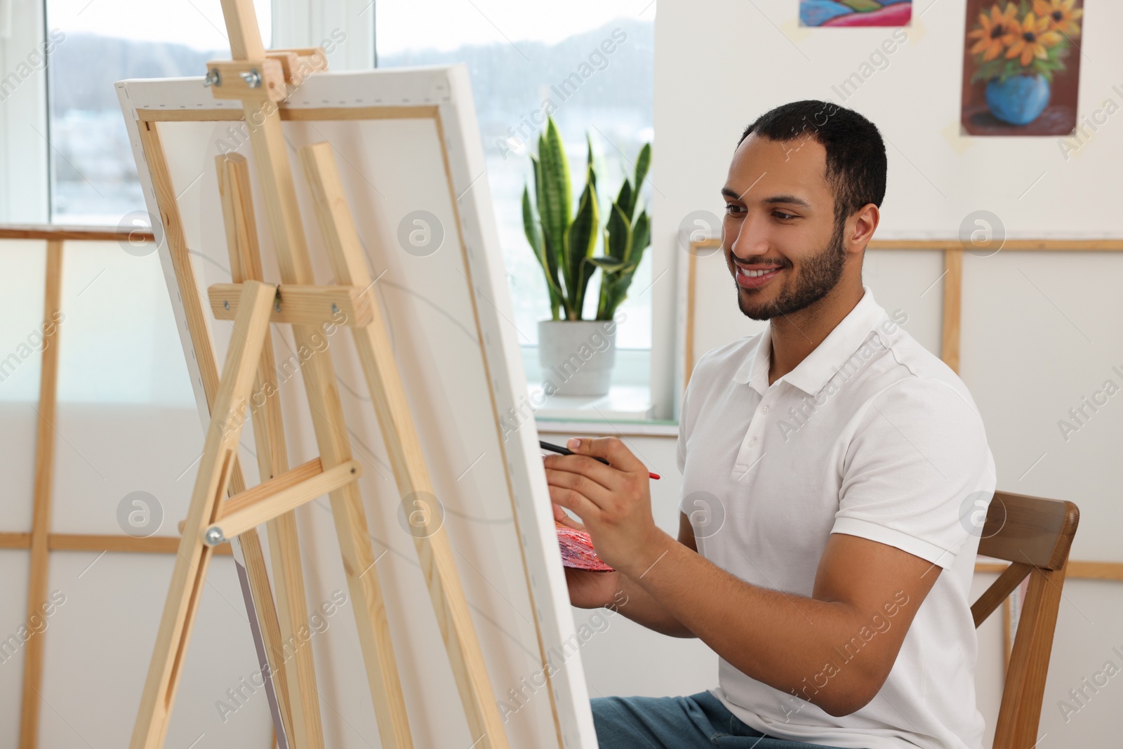 Photo of Young man painting in studio. Creative hobby